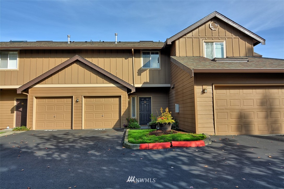 18930 Bothell Everett Highway, Unit M105 Bothell, WA 98012 - Photo 1 of 19 a front view of a house with garden