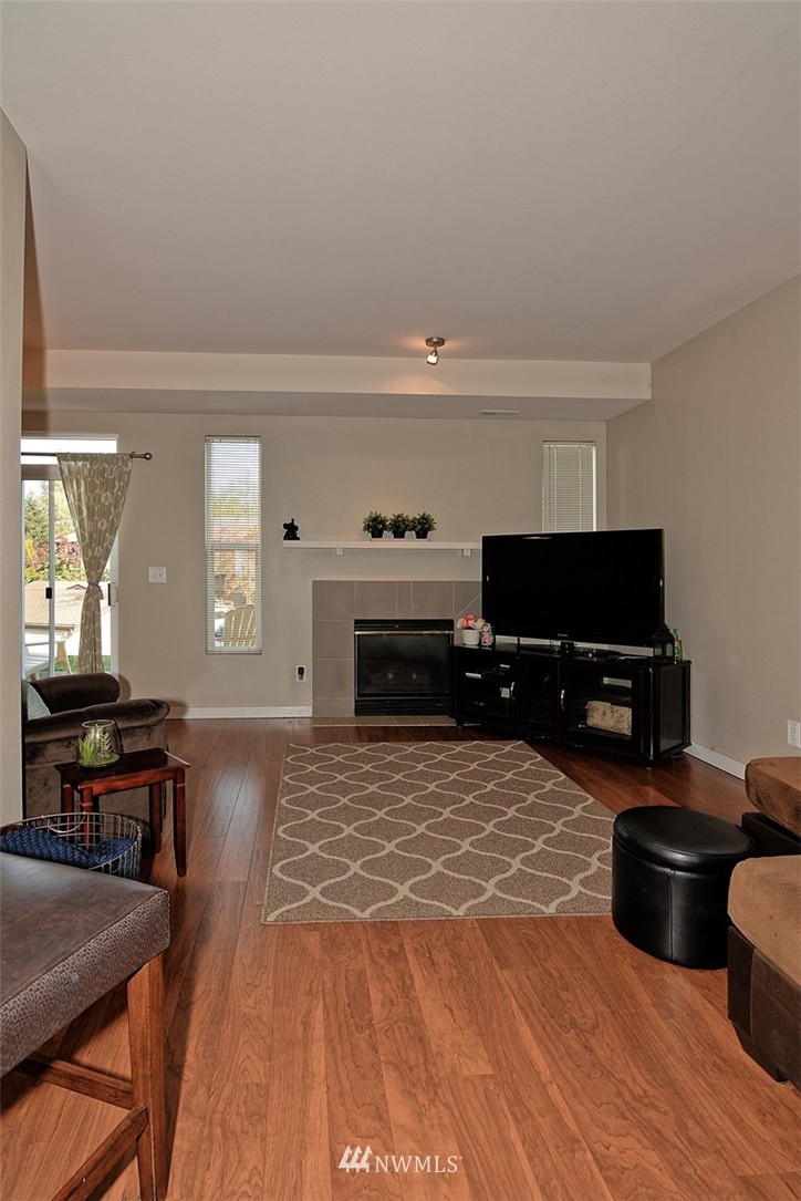 18930 Bothell Everett Highway, Unit M105 Bothell, WA 98012 - Photo 4 of 19 a living room with furniture a piano and a flat screen tv