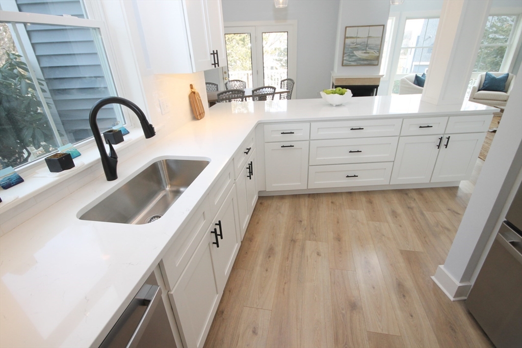 a kitchen with sink a microwave and wood floor