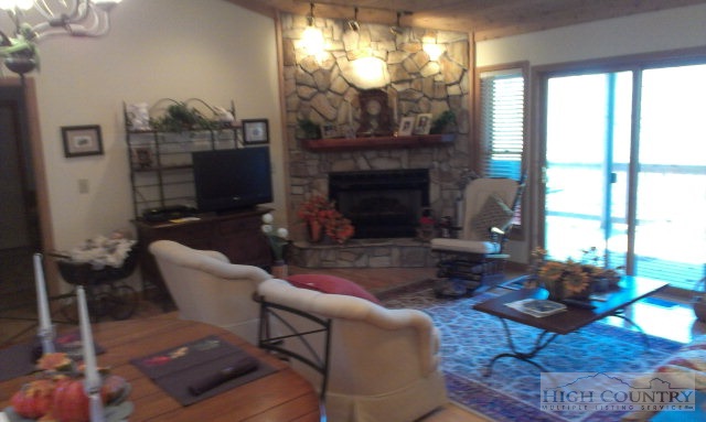 706 Pine Ridge Road Beech Mountain, NC 28604 - Photo 2 of 16 a living room with furniture a fireplace and a large window