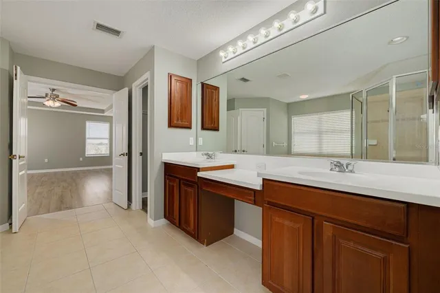 a bathroom with a sink double vanity granite tub and a mirror