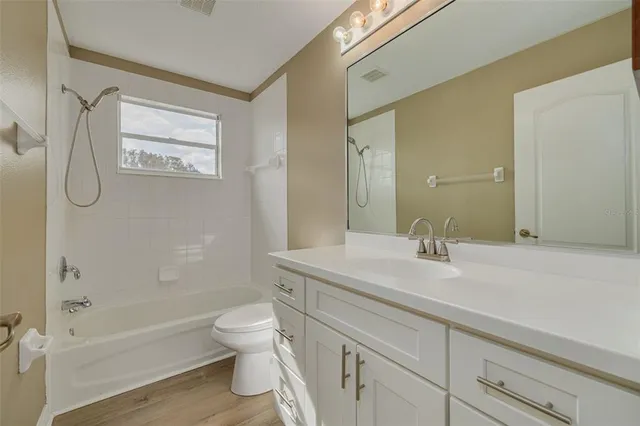 a bathroom with a granite countertop sink a toilet and a bathtub