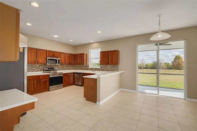 a large kitchen with kitchen island a sink a counter top stainless steel appliances and cabinets
