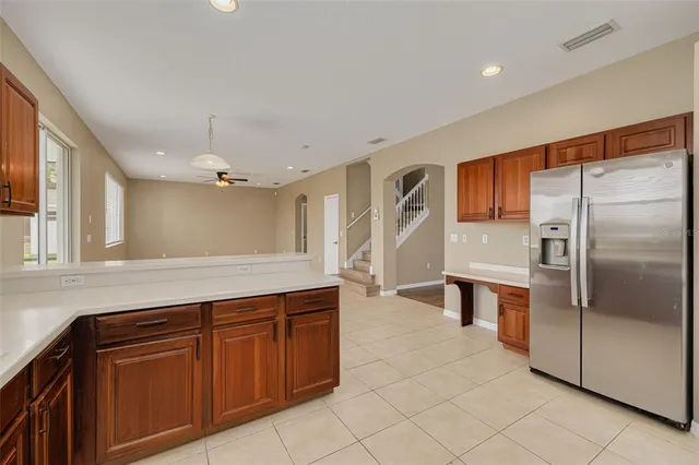 a kitchen with granite countertop a refrigerator and cabinets