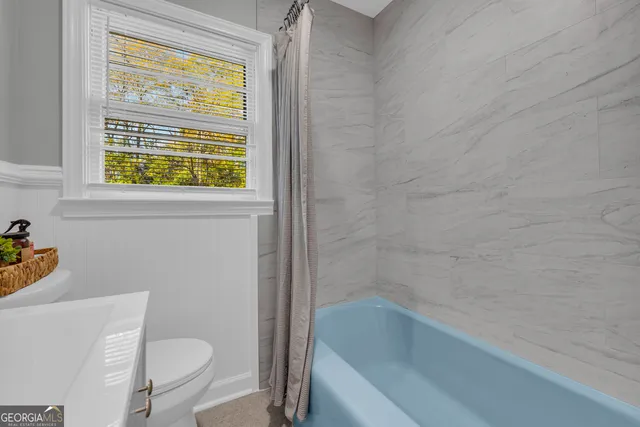 a white bath tub sitting next to a toilet