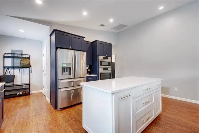 a kitchen with a refrigerator and a stove top oven