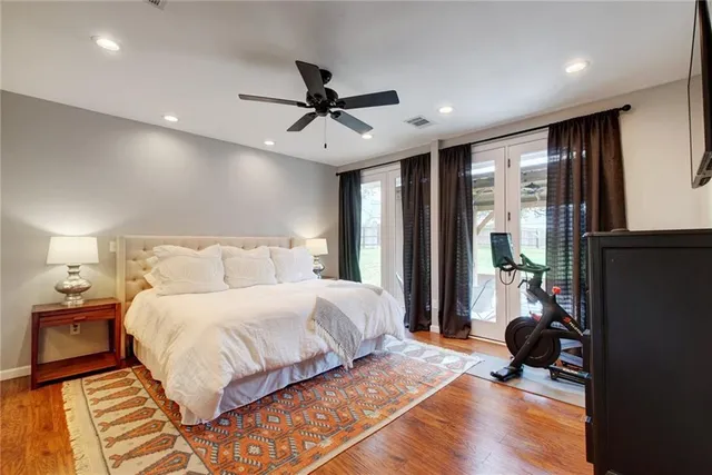 a bedroom with a bed painting on wall and a large window