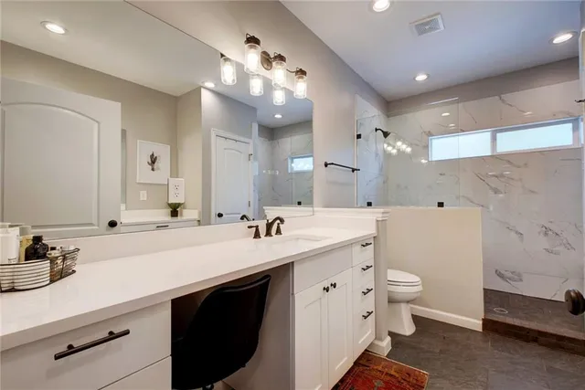 a bathroom with a double vanity sink mirror and toilet