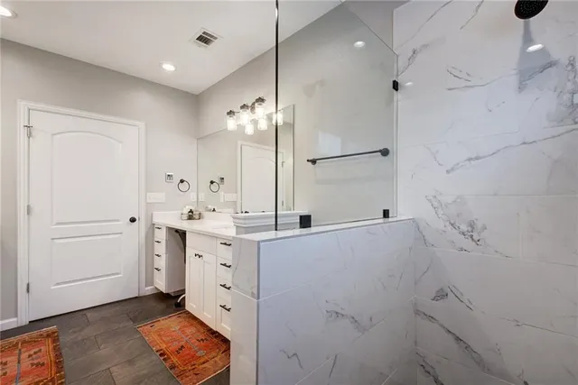 a spacious bathroom with a double vanity sink a mirror and shower