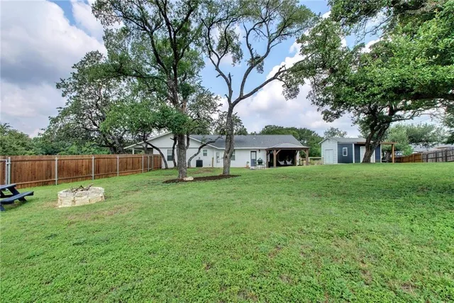 a front view of a house with garden and trees