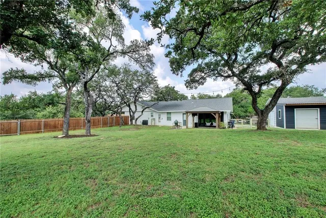 a view of a house with a backyard and a tree