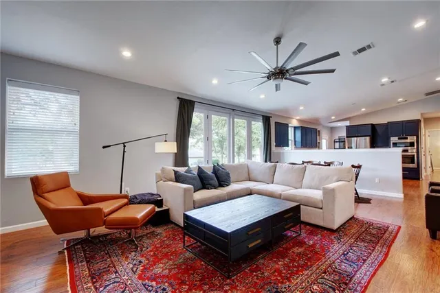 a living room with furniture a ceiling fan and a rug