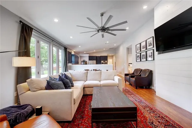 a living room with furniture a flat screen tv and a large window