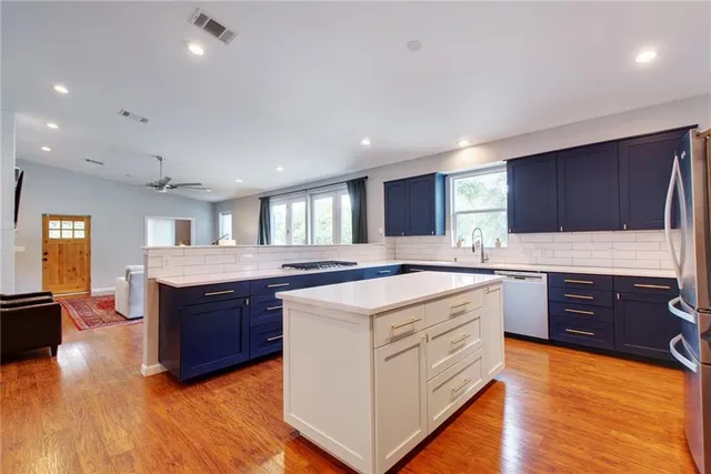 a kitchen with stainless steel appliances granite countertop wooden cabinets and sink