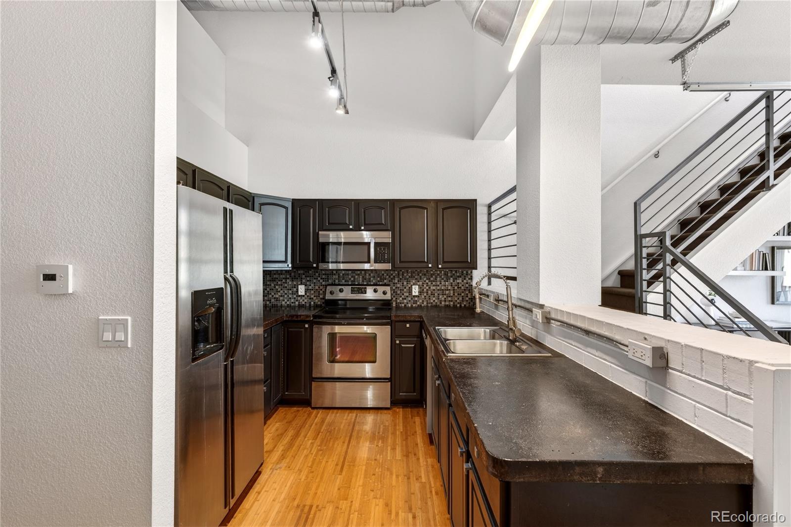 1421 Oneida Street, Unit 7 Denver, CO 80220 - Photo 10 of 22 a kitchen with stainless steel appliances granite countertop a sink a stove and a refrigerator