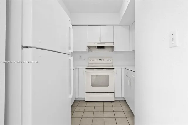 a view of a kitchen with white cabinets and white appliances