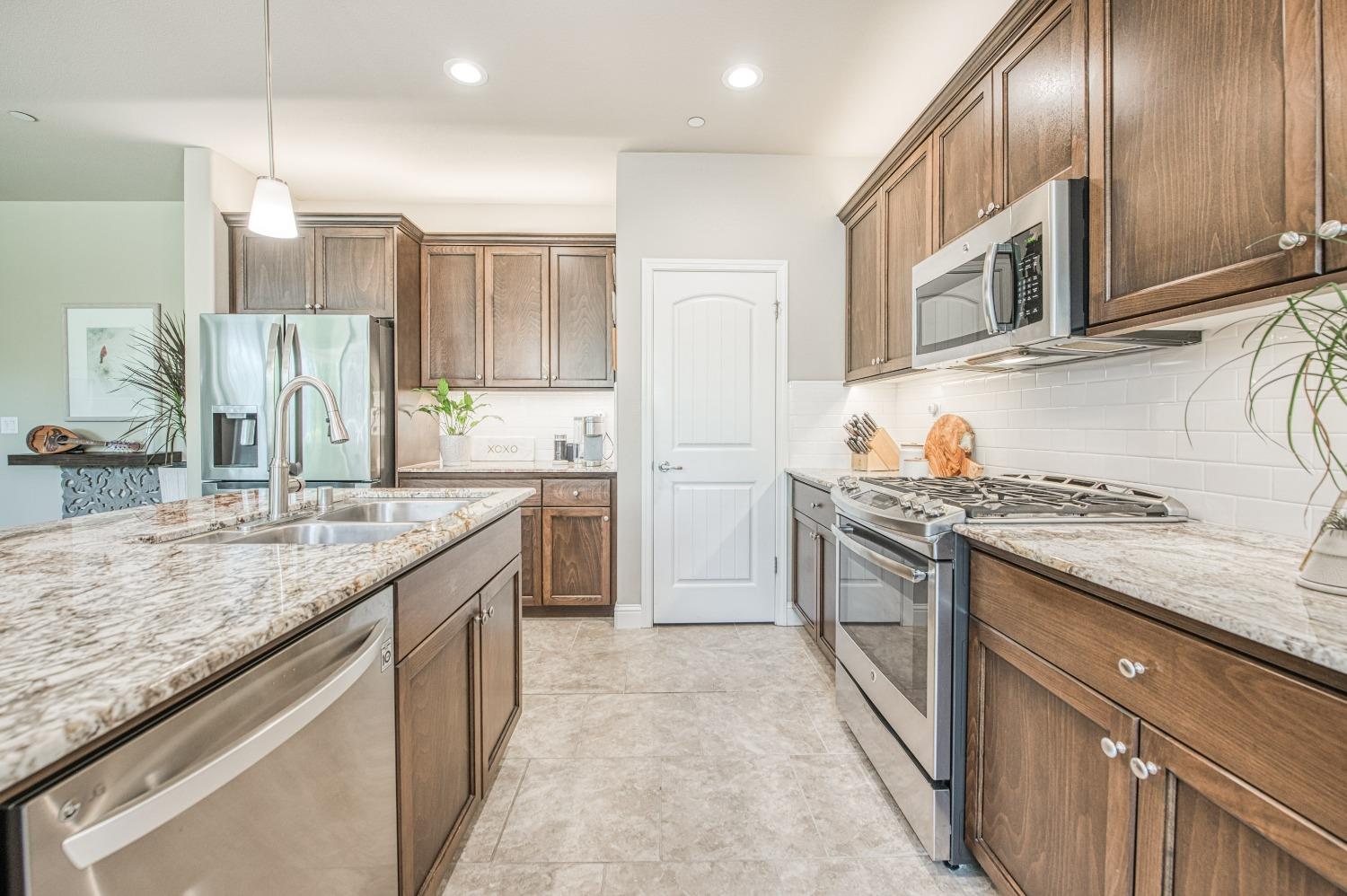 3479 Park Avenue Clovis, CA 93611 - Photo 17 of 27 a kitchen with stainless steel appliances granite countertop a sink stove and refrigerator