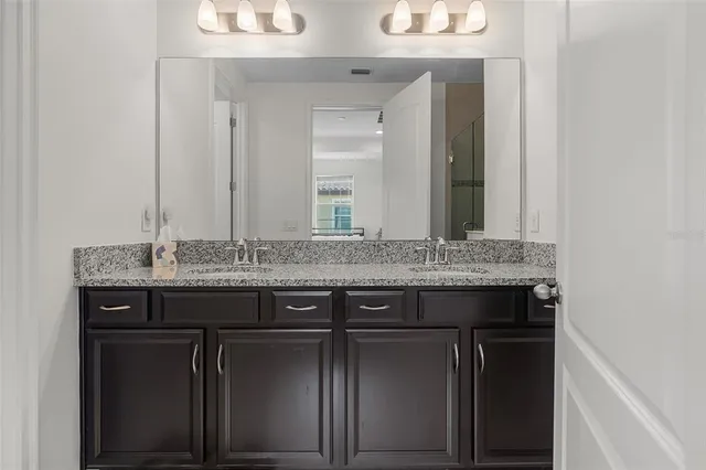 a bathroom with a granite countertop sink and a mirror