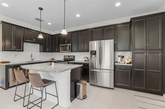 a kitchen with kitchen island a counter space cabinets and stainless steel appliances