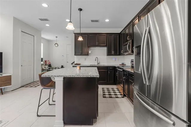 a kitchen with stainless steel appliances a sink stove and refrigerator