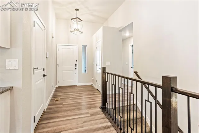 a view of a hallway with wooden floor and staircase