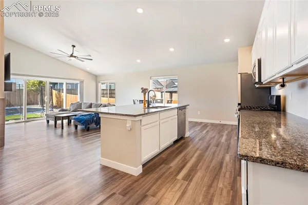 a kitchen with counter top space and wooden floor