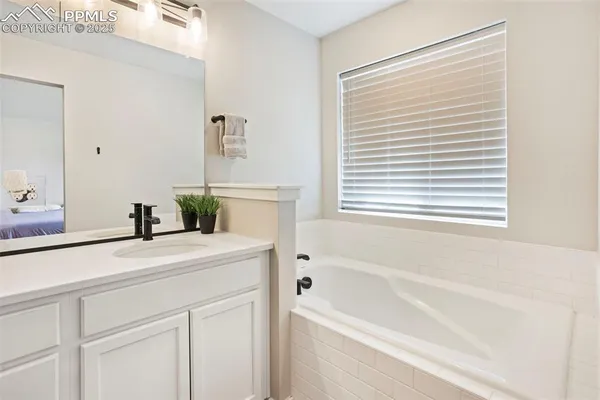 a bathroom with a bathtub a sink and a window