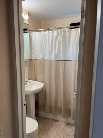 a bathroom with a sink a toilet a mirror and shower