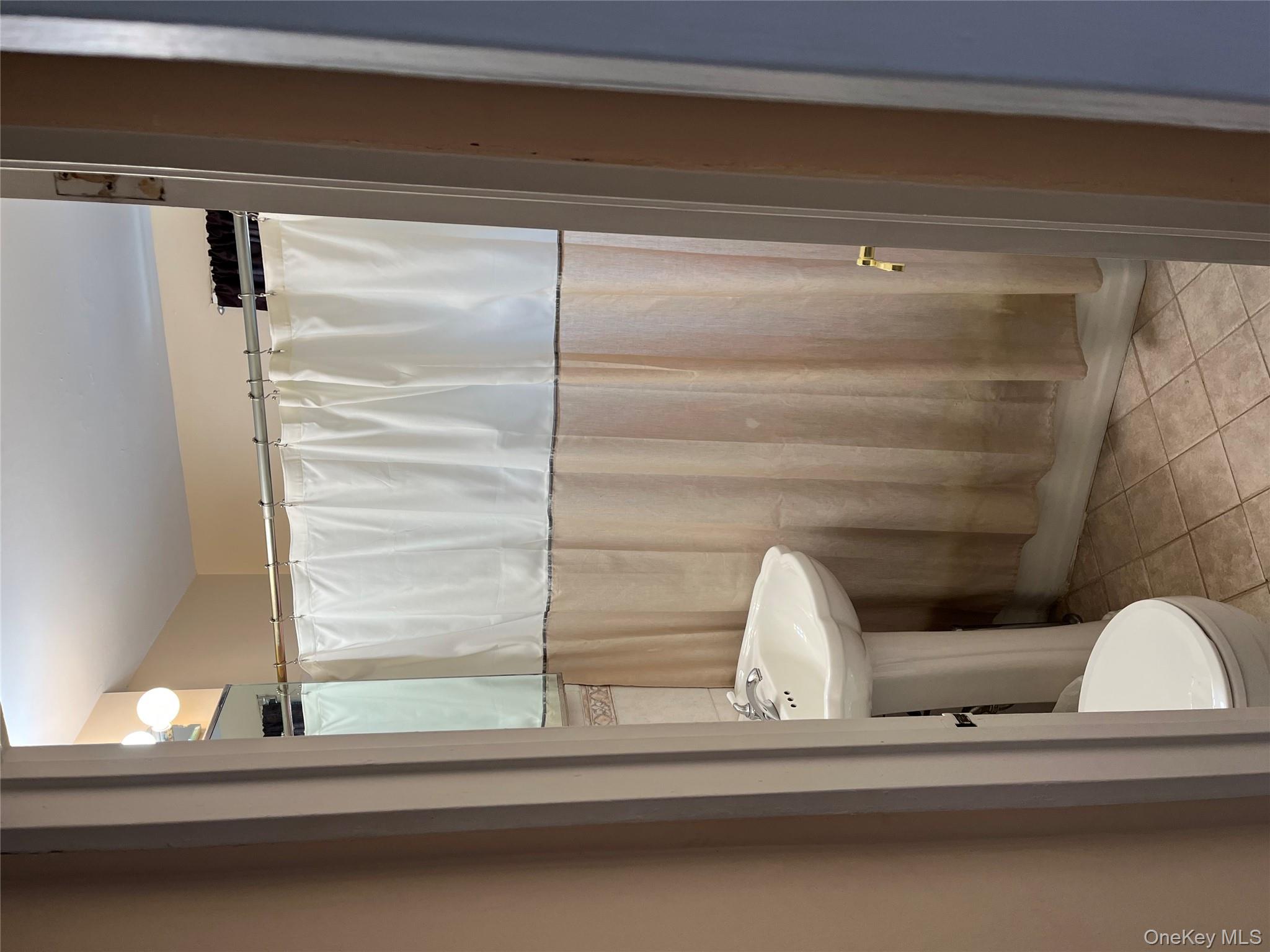 21-38 202nd Street, Unit 2 Queens, NY 11360 - Photo 10 of 11 a bathroom with a sink a toilet a mirror and shower