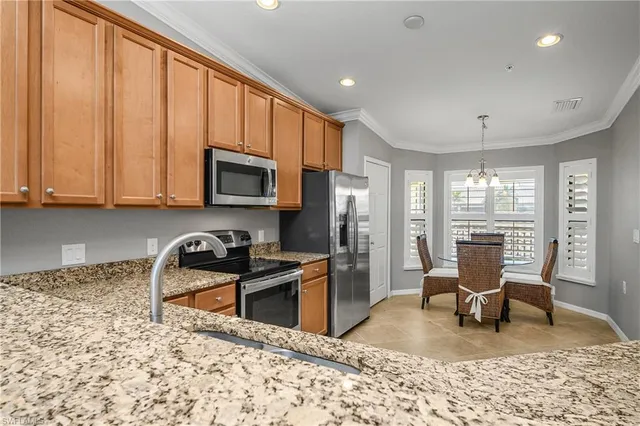 a kitchen with stainless steel appliances granite countertop sink stove refrigerator dining table and chairs
