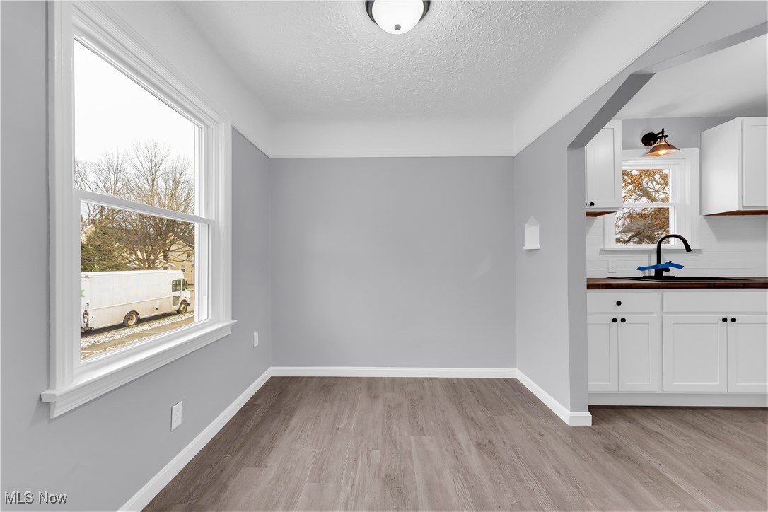 953 Whitby Road Cleveland Heights, OH 44112 - Photo 8 of 27 Unfurnished dining area featuring light wood-type flooring and a textured ceiling