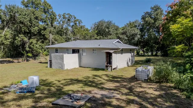 a view of a house with backyard and trees