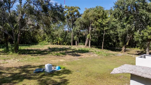 a backyard of a house with trees and trampoline