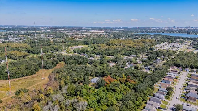 an aerial view of residential houses with outdoor space and trees