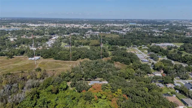 an aerial view of residential houses with outdoor space and trees