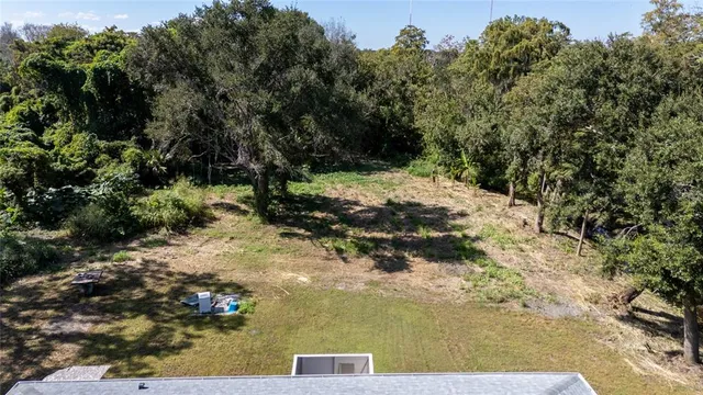 a backyard of a house with trees and trampoline