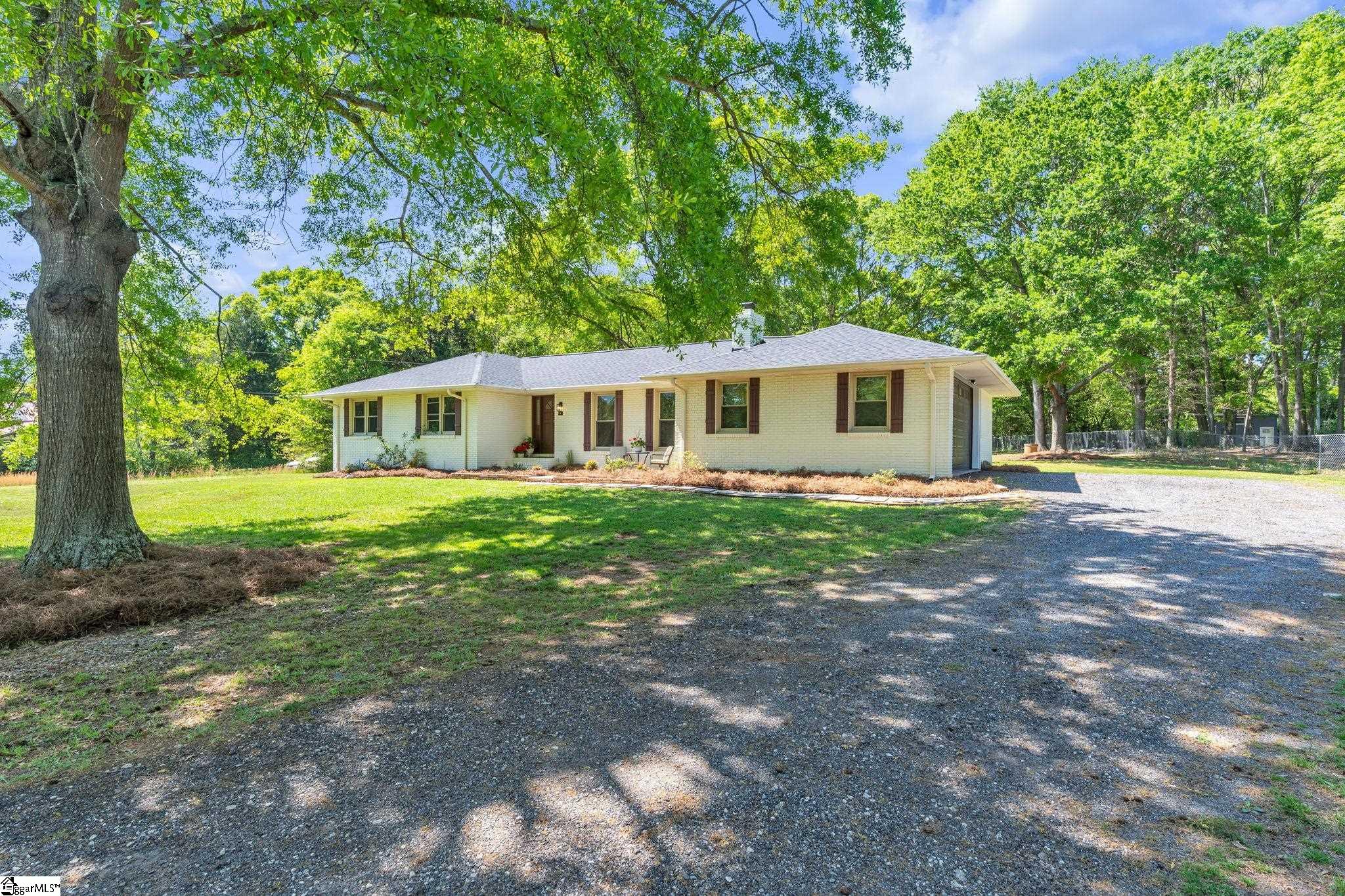 Home sits off the road with a long driveway and side entry garage. Great curb appeal with pretty shade trees as well.