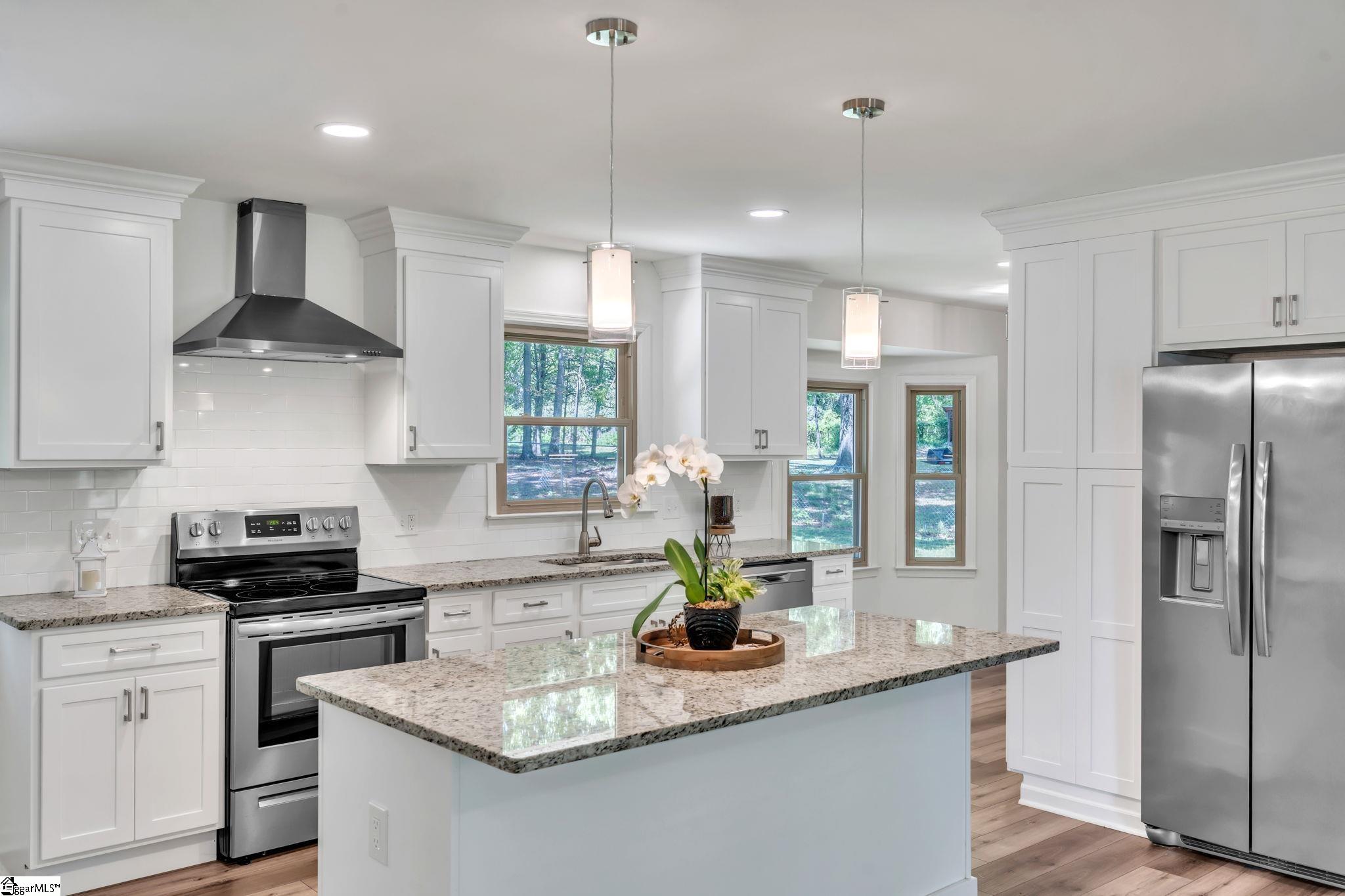 745 Canterbury Trail Fountain Inn, SC 29644 - Photo 3 of 25 Beautiful updated and upgraded kitchen with granite countertops, large island, soft close cabinets, and stainless steel appliances.