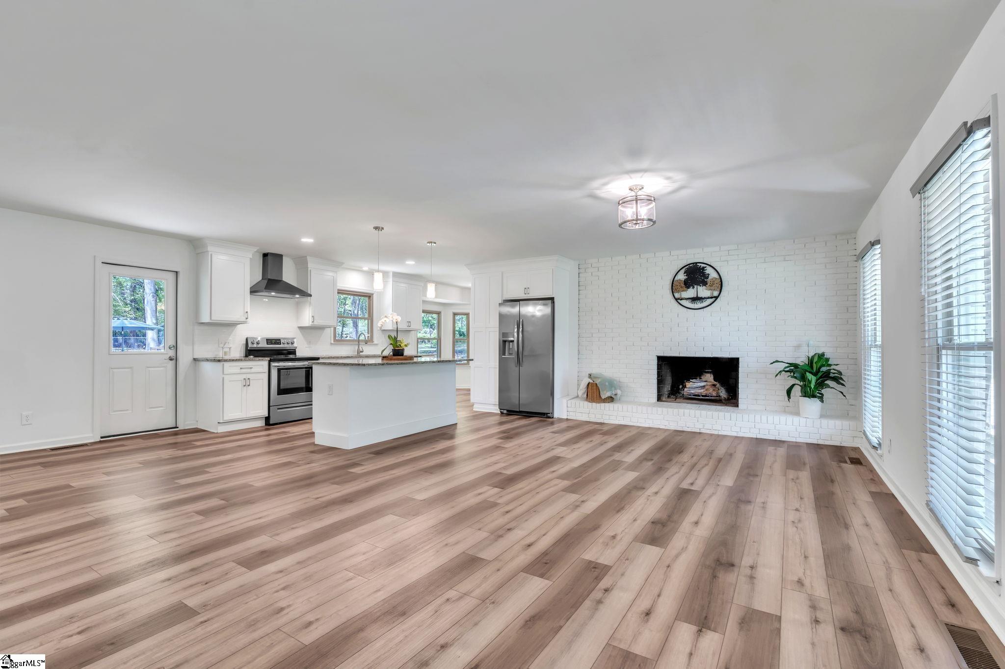 745 Canterbury Trail Fountain Inn, SC 29644 - Photo 25 of 25 Open floor plan. Living room has brick wood burning fireplace across one wall and is open to the large island and kitchen. All main flooring is LVP and has a smooth flowing across the main living areas.