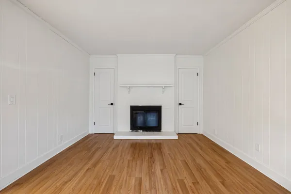 a view of a room with wooden floor and a fireplace