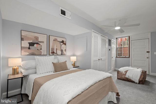 a bedroom with a large bed and a painting on the wall