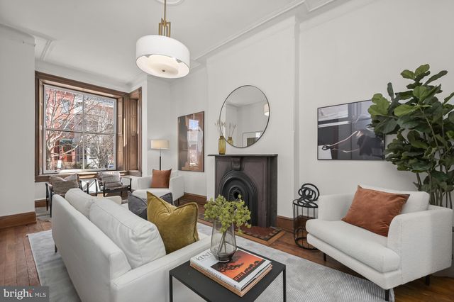 a living room with furniture a chandelier and a fireplace