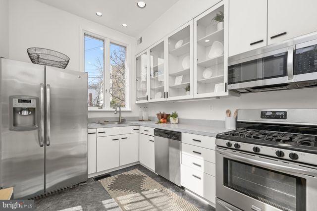 a kitchen with stainless steel appliances granite countertop a stove a microwave and a refrigerator
