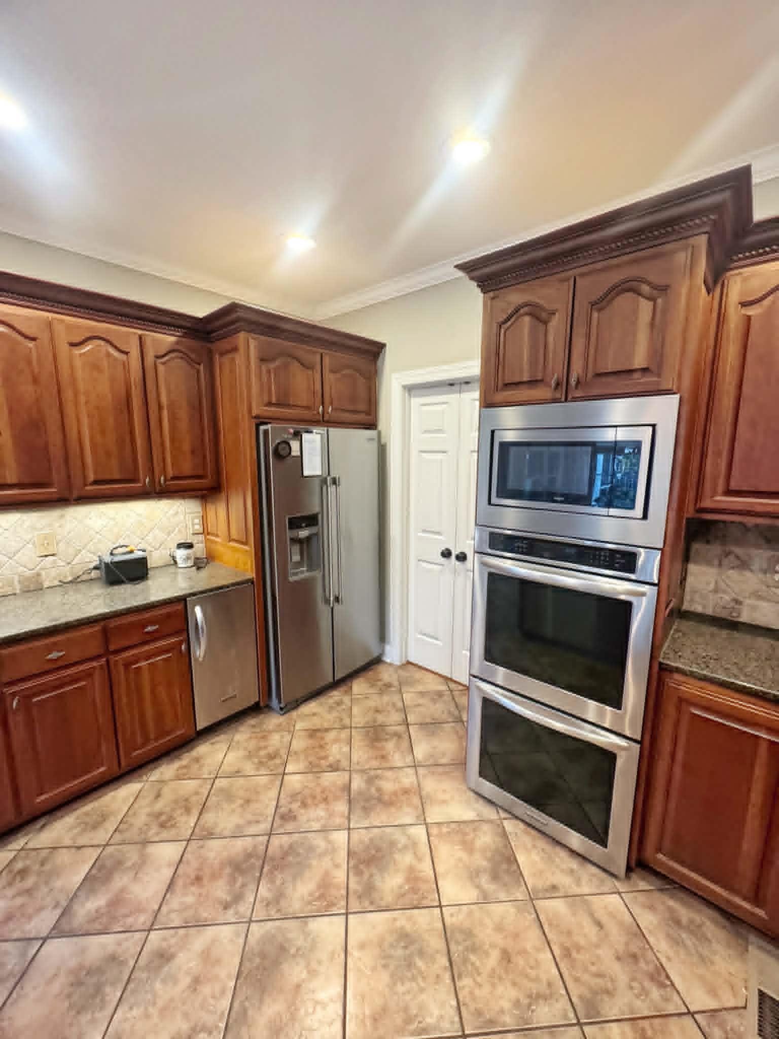 37 Crownpointe Cove Jackson, TN 38305 - Photo 11 of 39 Kitchen featuring wood cabinetry, stainless steel appliances, granite countertops, and a tiled backsplash