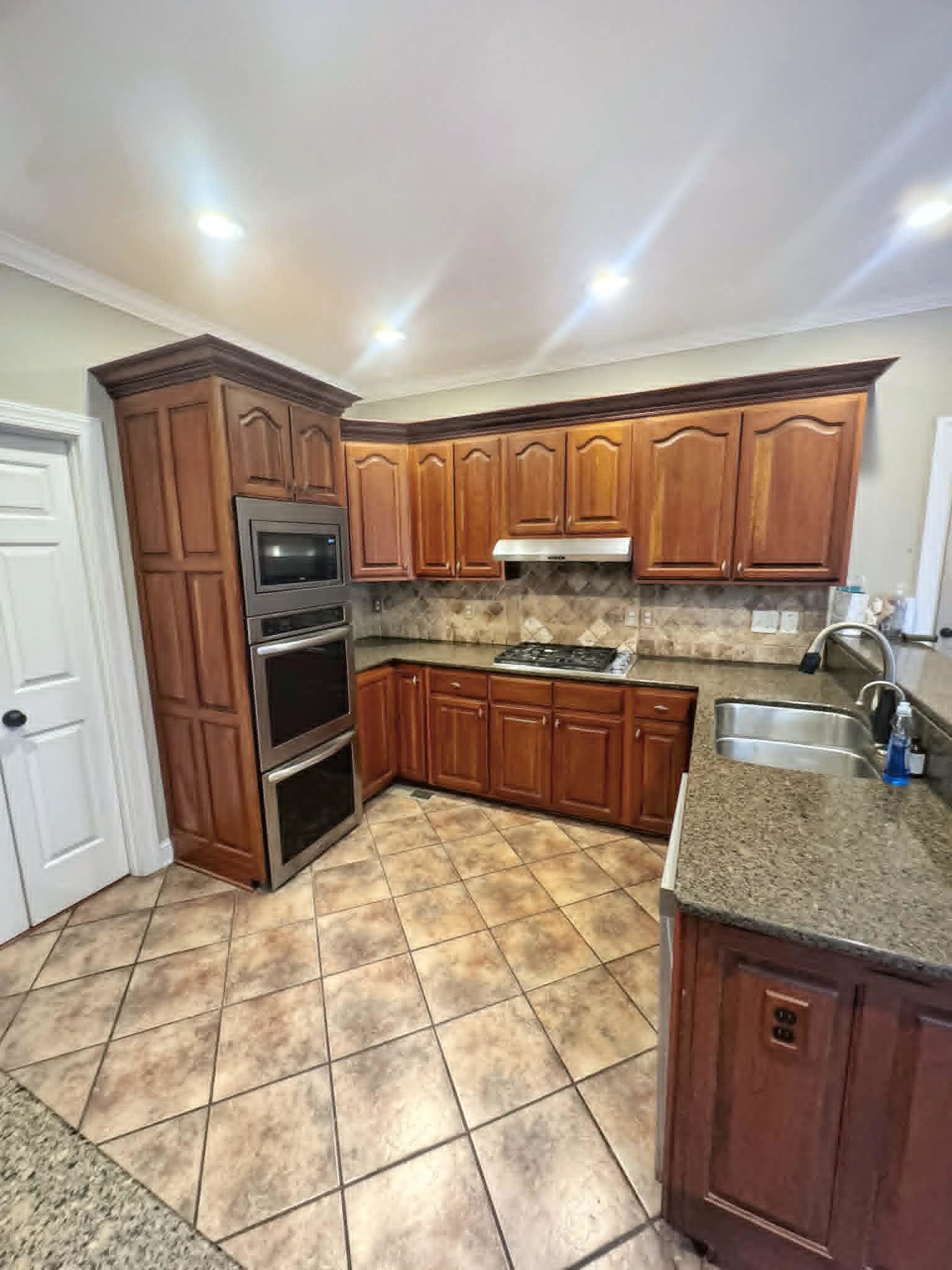 37 Crownpointe Cove Jackson, TN 38305 - Photo 12 of 39 Kitchen featuring wood cabinetry, stainless steel double wall oven, stainless steel built-in microwave, gas cooktop, and granite countertops
