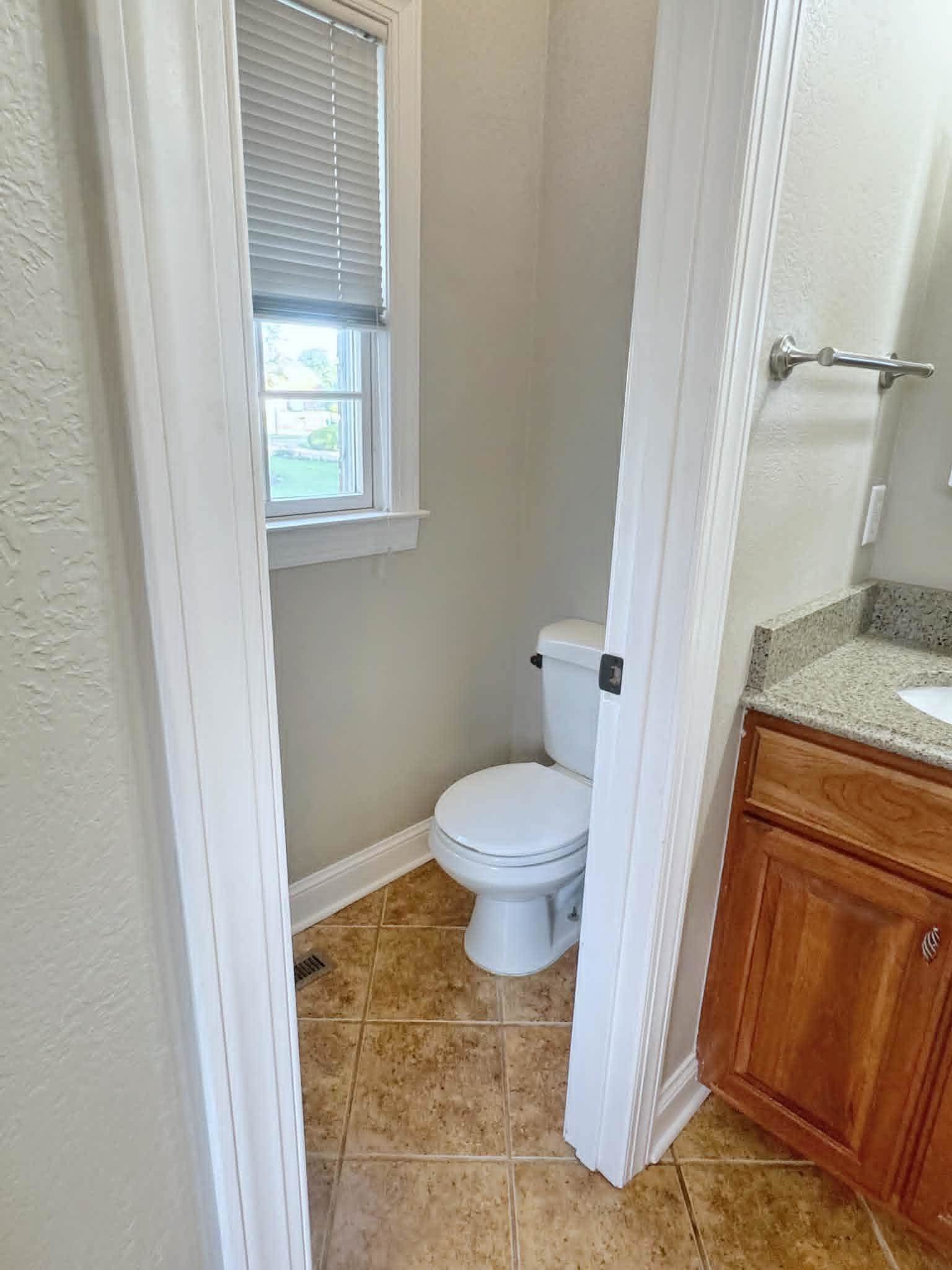 37 Crownpointe Cove Jackson, TN 38305 - Photo 19 of 39 Bathroom featuring a window with blinds, a toilet, tile flooring, and a vanity with a light-toned countertop and wood-finish cabinetry