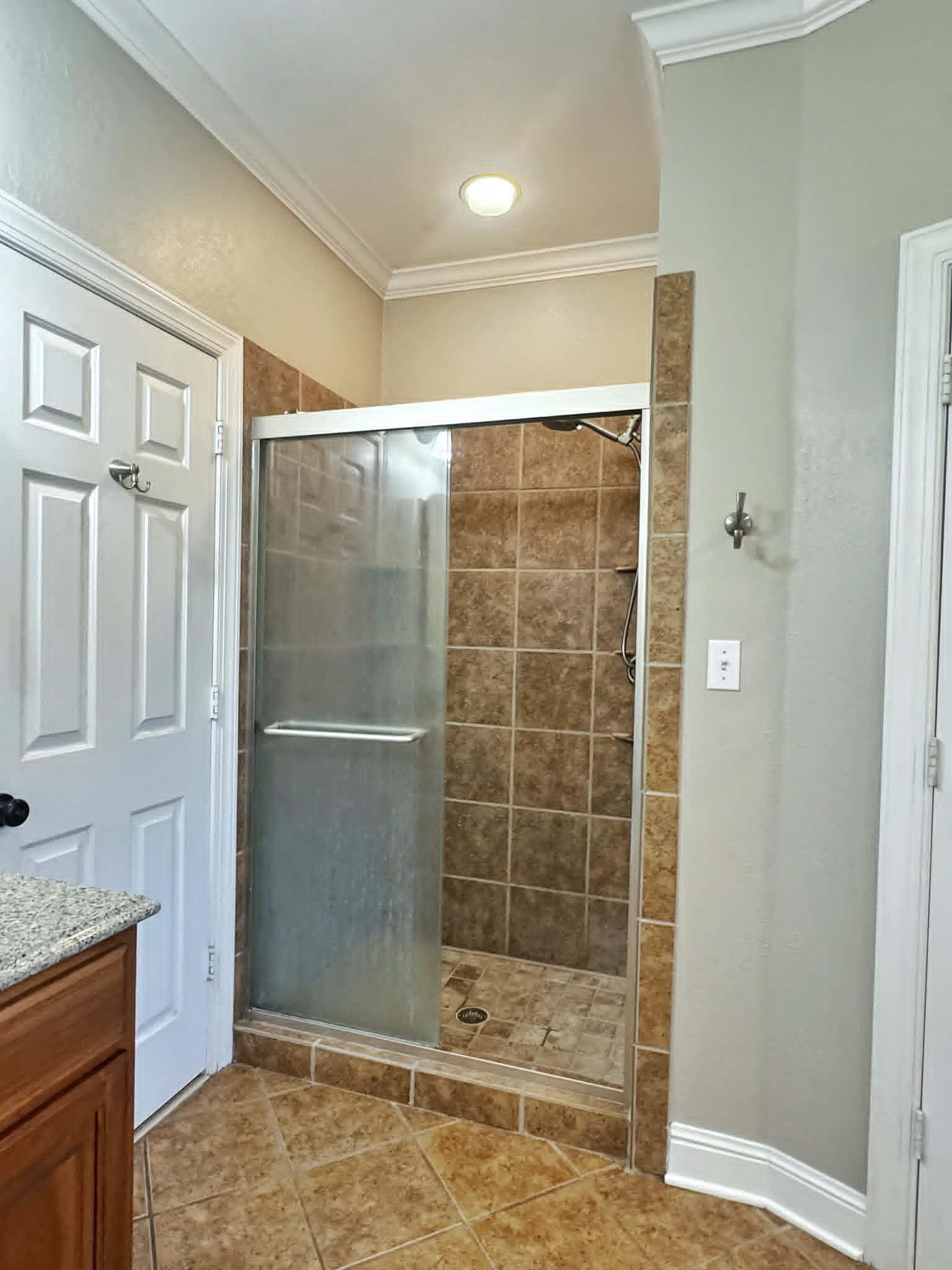 37 Crownpointe Cove Jackson, TN 38305 - Photo 21 of 39 Shower enclosure featuring a tile surround, glass sliding door, and integrated shower head