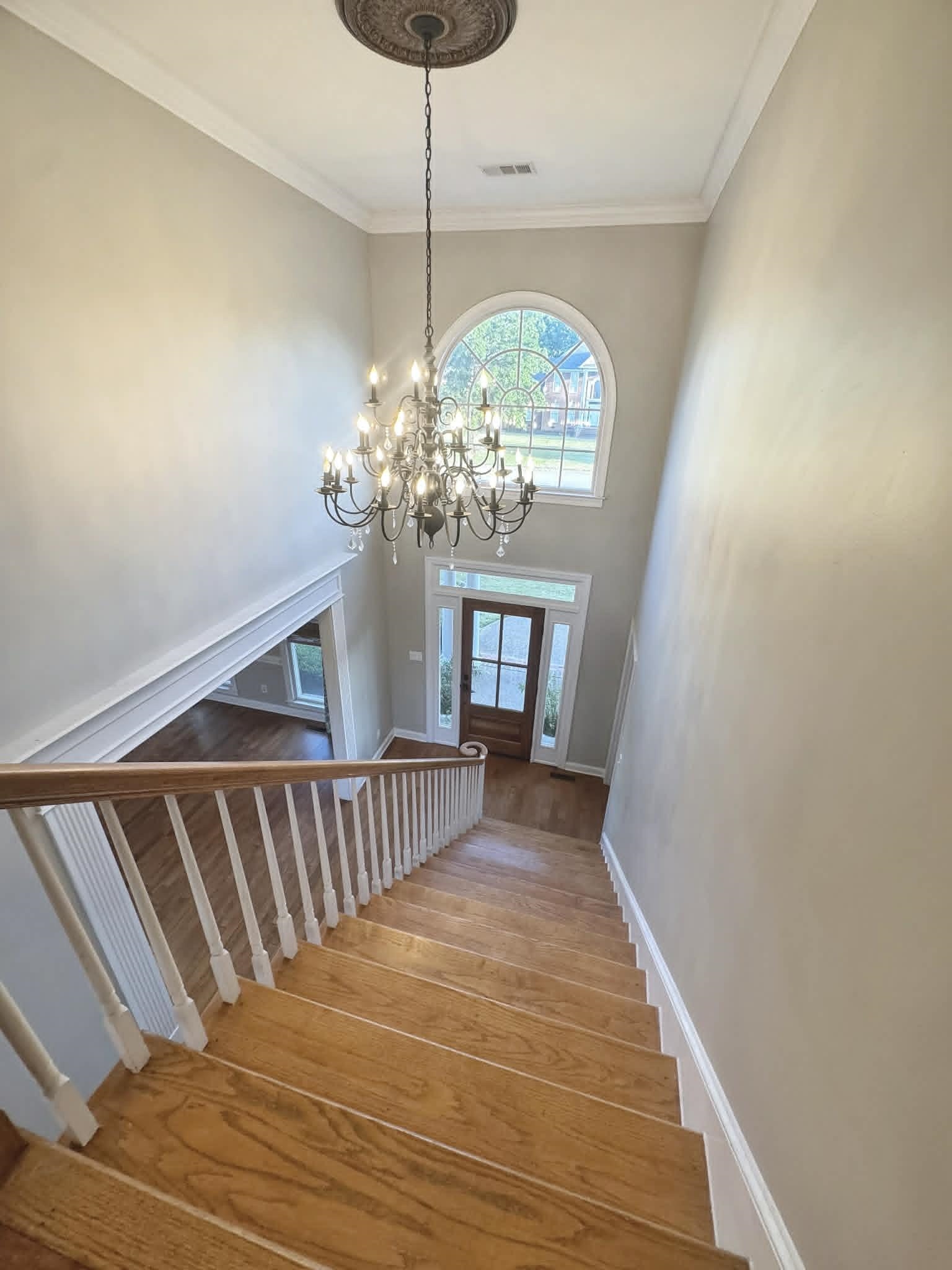 37 Crownpointe Cove Jackson, TN 38305 - Photo 24 of 39 Two-story foyer featuring a chandelier with a decorative ceiling medallion, an arched window, and wood-finish flooring