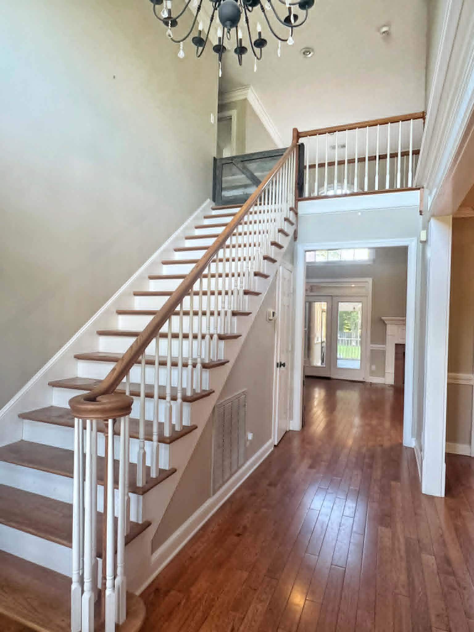 37 Crownpointe Cove Jackson, TN 38305 - Photo 4 of 39 Foyer featuring a grand staircase with wood-finish treads and white balusters, a decorative chandelier, and hardwood flooring