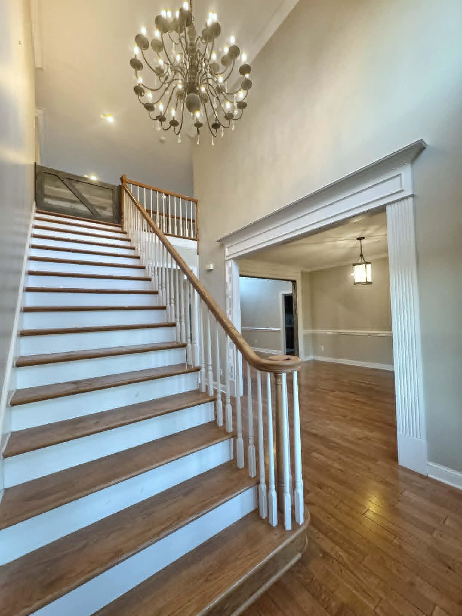 37 Crownpointe Cove Jackson, TN 38305 - Photo 5 of 39 Grand entryway featuring a double-height ceiling, decorative chandelier, wood-finish flooring, and a staircase with wood treads and white risers